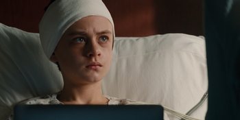 Movie still from “The Book of Henry” (2017), directed by Colin Trevorrow – A young person wearing a white hat looking at a laptop; Close Up shot, High angle