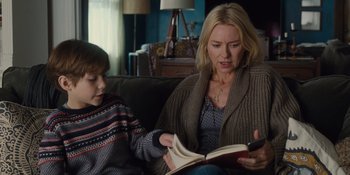 Movie still from “The Book of Henry” (2017), directed by Colin Trevorrow – A woman sitting on a couch reading a book to a boy; Medium shot, Over the shoulder angle