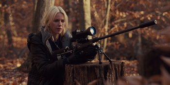Movie still from “The Book of Henry” (2017), directed by Colin Trevorrow – A woman is holding a rifle in the woods; Medium shot, Over the shoulder angle