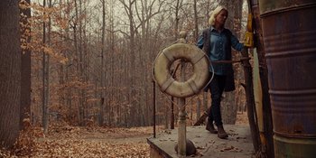 Movie still from “The Book of Henry” (2017), directed by Colin Trevorrow – A woman walking on a platform near a forest; Wide shot, Low angle