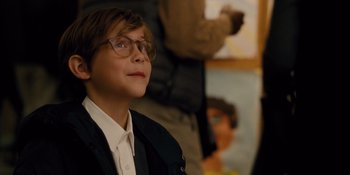 Movie still from “The Book of Henry” (2017), directed by Colin Trevorrow – A young boy wearing glasses looking up at something in the distance; Medium shot, Over the shoulder angle