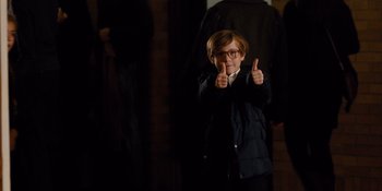 Movie still from “The Book of Henry” (2017), directed by Colin Trevorrow – A young boy giving two thumbs up in front of a brick wall; Medium shot, High angle