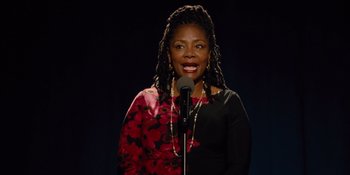 Movie still from “The Book of Henry” (2017), directed by Colin Trevorrow – A woman standing in front of a microphone on a stage; Close Up shot, Low angle