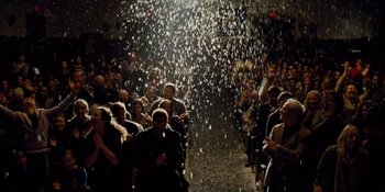 Movie still from “The Book of Henry” (2017), directed by Colin Trevorrow – A group of people sitting in front of an audience; Wide shot, Low angle