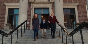 Movie still from “The Book of Henry” (2017), directed by Colin Trevorrow – A woman and two young children walking down the stairs; Wide shot, Low angle
