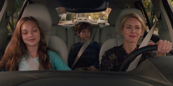 Movie still from “The Book of Henry” (2017), directed by Colin Trevorrow – Three people sitting in the back seat of a car; Medium shot, Over the shoulder angle