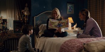 Movie still from “The Book of Henry” (2017), directed by Colin Trevorrow – A woman sitting on top of a bed reading a book to a boy; Medium shot, Over the shoulder angle