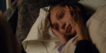 Movie still from “The Book of Henry” (2017), directed by Colin Trevorrow – A young girl laying in bed with her head on a pillow; Close Up shot, High angle