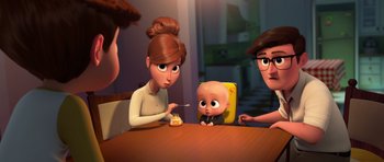 Movie still from “The Boss Baby” (2017), directed by Tom McGrath – A group of people sitting at a table with a baby; Medium shot, Over the shoulder angle