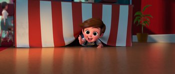 Movie still from “The Boss Baby” (2017), directed by Tom McGrath – A boy is hiding under a striped curtain; Wide shot, High angle