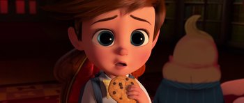 Movie still from “The Boss Baby” (2017), directed by Tom McGrath – A boy holding a chocolate chip cookie in front of his face; Close Up shot, High angle