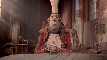 Movie still from “The Boxtrolls” (2014), directed by Anthony Stacchi – A person sitting at a table wearing a chef's hat; Medium shot, Low angle