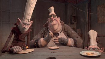 Movie still from “The Boxtrolls” (2014), directed by Anthony Stacchi – A man sitting at a table with a plate in front of him; Medium shot, Low angle