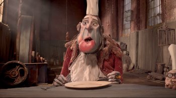 Movie still from “The Boxtrolls” (2014), directed by Anthony Stacchi – A man in a chef's outfit sitting in front of a plate; Close Up shot, Low angle