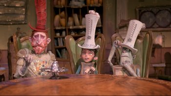 Movie still from “The Boxtrolls” (2014), directed by Anthony Stacchi – A group of people sitting at a table with a doll on top of their head; Medium shot, Low angle