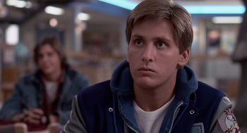 A young man looking to his left while sitting at a table