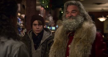 Movie still from “The Christmas Chronicles” (2018), directed by Clay Kaytis – A man and a boy standing next to each other in front of a christmas tree; Medium shot, Over the shoulder angle