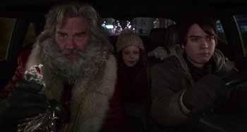 Movie still from “The Christmas Chronicles” (2018), directed by Clay Kaytis – A group of people riding in a car on a street; Close Up shot, Over the shoulder angle