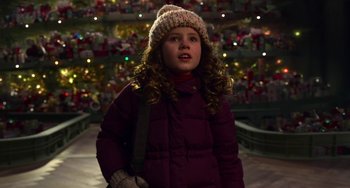 Movie still from “The Christmas Chronicles” (2018), directed by Clay Kaytis – A little girl wearing a purple coat and a white hat; Medium shot, High angle