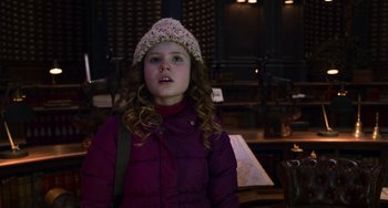Movie still from “The Christmas Chronicles” (2018), directed by Clay Kaytis – A little girl wearing a purple jacket and a hat; Close Up shot, Over the shoulder angle