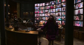 Movie still from “The Christmas Chronicles” (2018), directed by Clay Kaytis – A little girl standing in front of a wall of pictures; Wide shot, Over the shoulder angle