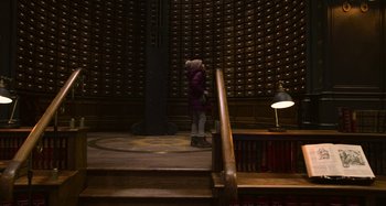 Movie still from “The Christmas Chronicles” (2018), directed by Clay Kaytis – A person standing in front of a wall of books; Wide shot, Low angle