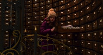 Movie still from “The Christmas Chronicles” (2018), directed by Clay Kaytis – A little girl standing in front of a bunch of drawers; Medium shot, Low angle