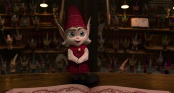 Movie still from “The Christmas Chronicles” (2018), directed by Clay Kaytis – An elf doll standing in front of an open book; Medium shot, High angle