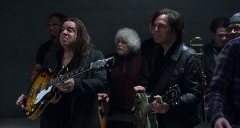 Movie still from “The Christmas Chronicles” (2018), directed by Clay Kaytis – A group of people standing next to each other holding guitars; Medium shot, Low angle