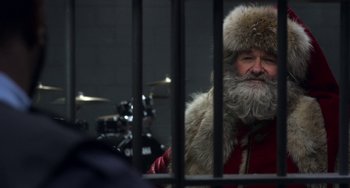 Movie still from “The Christmas Chronicles” (2018), directed by Clay Kaytis – A man with a beard and a fur hat behind bars; Close Up shot, Over the shoulder angle