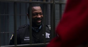 Movie still from “The Christmas Chronicles” (2018), directed by Clay Kaytis – A man in a police uniform sitting behind bars; Close Up shot, Over the shoulder angle
