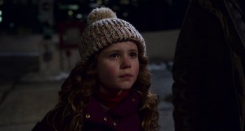 Movie still from “The Christmas Chronicles” (2018), directed by Clay Kaytis – A little girl wearing a hat and a scarf; Close Up shot, Over the shoulder angle