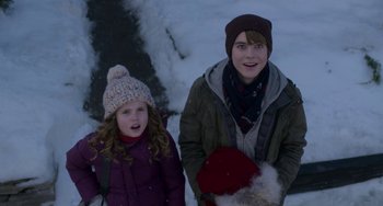 Movie still from “The Christmas Chronicles” (2018), directed by Clay Kaytis – Two people standing next to each other in the snow; Medium shot, Over the shoulder angle