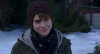 Movie still from “The Christmas Chronicles” (2018), directed by Clay Kaytis – A young man wearing a hat and a scarf in the snow; Close Up shot, Over the shoulder angle