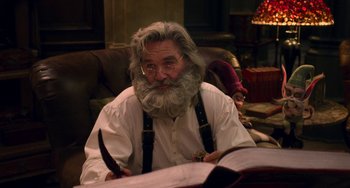 Movie still from “The Christmas Chronicles” (2018), directed by Clay Kaytis – An old man with a long white beard holding a knife; Medium shot, Over the shoulder angle