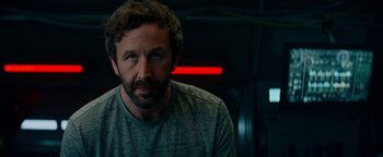 Movie still from “The Cloverfield Paradox” (2018), directed by Julius Onah – A person wearing a gray shirt; Close Up shot, Over the shoulder angle