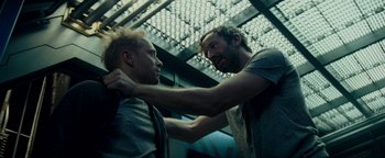 Movie still from “The Cloverfield Paradox” (2018), directed by Julius Onah – Two men are fighting in front of the lights; Close Up shot, Over the shoulder angle