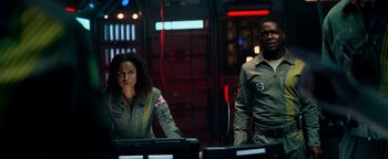 Movie still from “The Cloverfield Paradox” (2018), directed by Julius Onah – A man and a woman are standing in front of computer monitors; Medium shot, Low angle