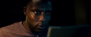 Movie still from “The Cloverfield Paradox” (2018), directed by Julius Onah – A person using a laptop computer; Close Up shot, Low angle