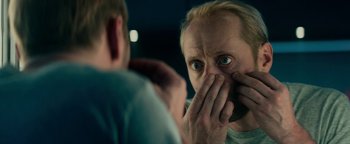 Movie still from “The Cloverfield Paradox” (2018), directed by Julius Onah – A man looking at himself in the mirror while covering his mouth; Close Up shot, Over the shoulder angle