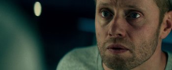Movie still from “The Cloverfield Paradox” (2018), directed by Julius Onah – A man's face in a dark room; Close Up shot, Overhead angle