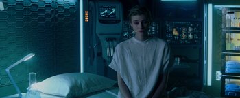 Movie still from “The Cloverfield Paradox” (2018), directed by Julius Onah – A woman in a white shirt standing next to a bed; Medium shot, High angle