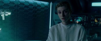 Movie still from “The Cloverfield Paradox” (2018), directed by Julius Onah – A woman in white shirt standing next to a wall; Close Up shot, Over the shoulder angle