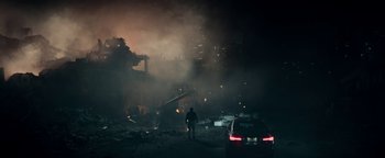 Movie still from “The Cloverfield Paradox” (2018), directed by Julius Onah – A man standing in front of a car in the dark; Extreme Wide shot, Over the shoulder angle