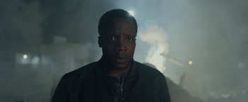 Movie still from “The Cloverfield Paradox” (2018), directed by Julius Onah – A man in a black jacket is looking at the camera; Close Up shot, Low angle
