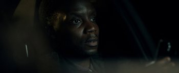 Movie still from “The Cloverfield Paradox” (2018), directed by Julius Onah – A man's face in the dark; Close Up shot, Over the shoulder angle