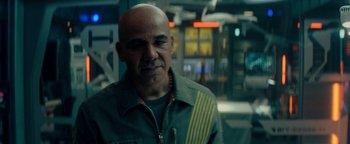 Movie still from “The Cloverfield Paradox” (2018), directed by Julius Onah – A man with bald head wearing a green jacket; Close Up shot, Over the shoulder angle