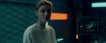 Movie still from “The Cloverfield Paradox” (2018), directed by Julius Onah – A man with blonde hair standing in front of an orange wall; Close Up shot, Over the shoulder angle