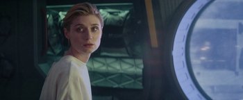 Movie still from “The Cloverfield Paradox” (2018), directed by Julius Onah – A young woman is looking at the camera while standing in front of a building; Close Up shot, Over the shoulder angle