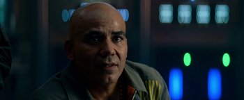 Movie still from “The Cloverfield Paradox” (2018), directed by Julius Onah – A man with bald head looking into the camera; Close Up shot, Over the shoulder angle